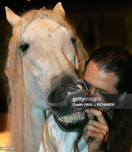 Arlington, UNITED STATES: Frenchman Frederic Pignon, equestrian co-director of Cavalia, tickles Aetes' teeth, a white Spanish-Friesian stallion,...