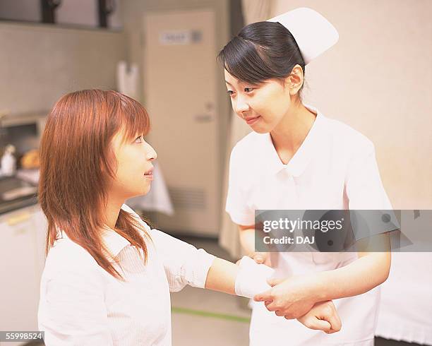 patient getting injured hand bandaged - wrapping arm stock pictures, royalty-free photos & images