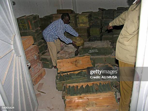 This picture taken 24 October 2005 shows a man showing thousand of landmines handed over by Somali warlord and minister, Hussein Mohamed Aidid to an...