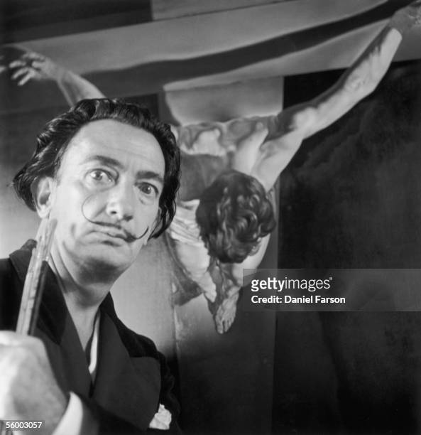 Spanish surrealist painter Salvador Dali in his studio in Port Lligat with his painting entitled 'Christ of St John on the Cross', 17th November...