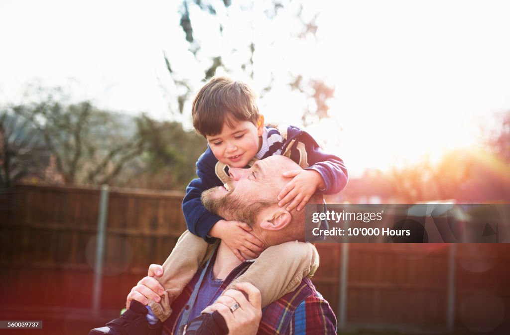 Son sitting on father's shoulders