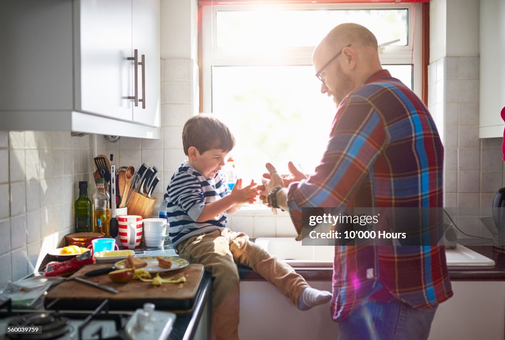 Father and son playing in the kitchen