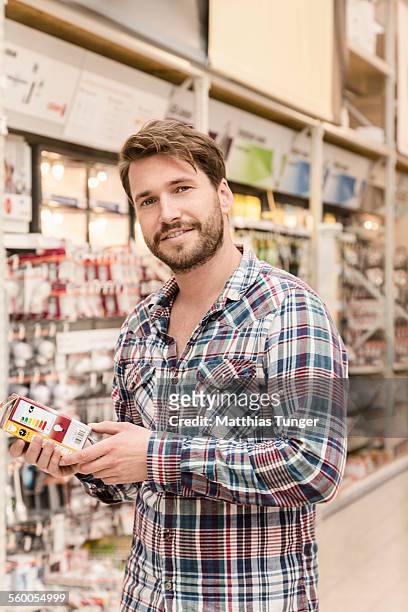 young man looking for a light bulb - baumarkt stock pictures, royalty-free photos & images