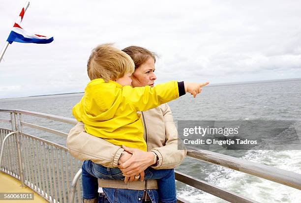 young mother and her son looking out over the sea - vlieland stock pictures, royalty-free photos & images