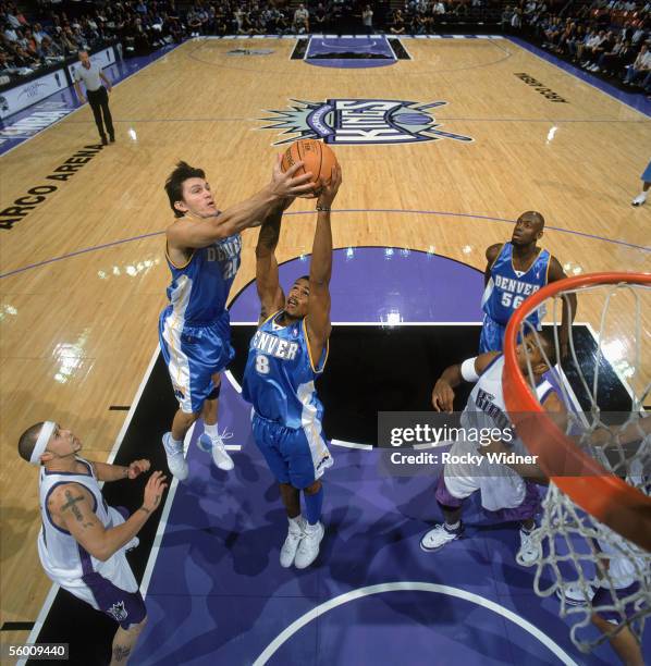 Earl Watson and Eduardo Najera of the Denver Nuggets reach for the rebound against the Sacramento Kings during a game at Arco Arena on October 18,...