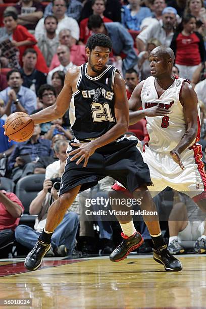 Tim Duncan of the San Antonio Spurs moves the ball against Antoine Walker of the Miami Heat during the Hurricane Katrina Relief Benefit Game at...