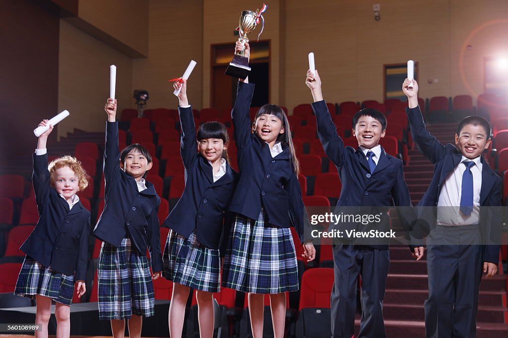 Exciting pupil with a prize in the auditorium