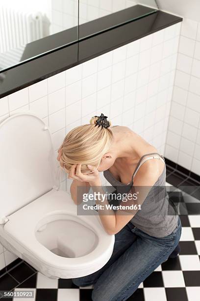 despaired anorexic young woman at the toilet - bulimie stock-fotos und bilder