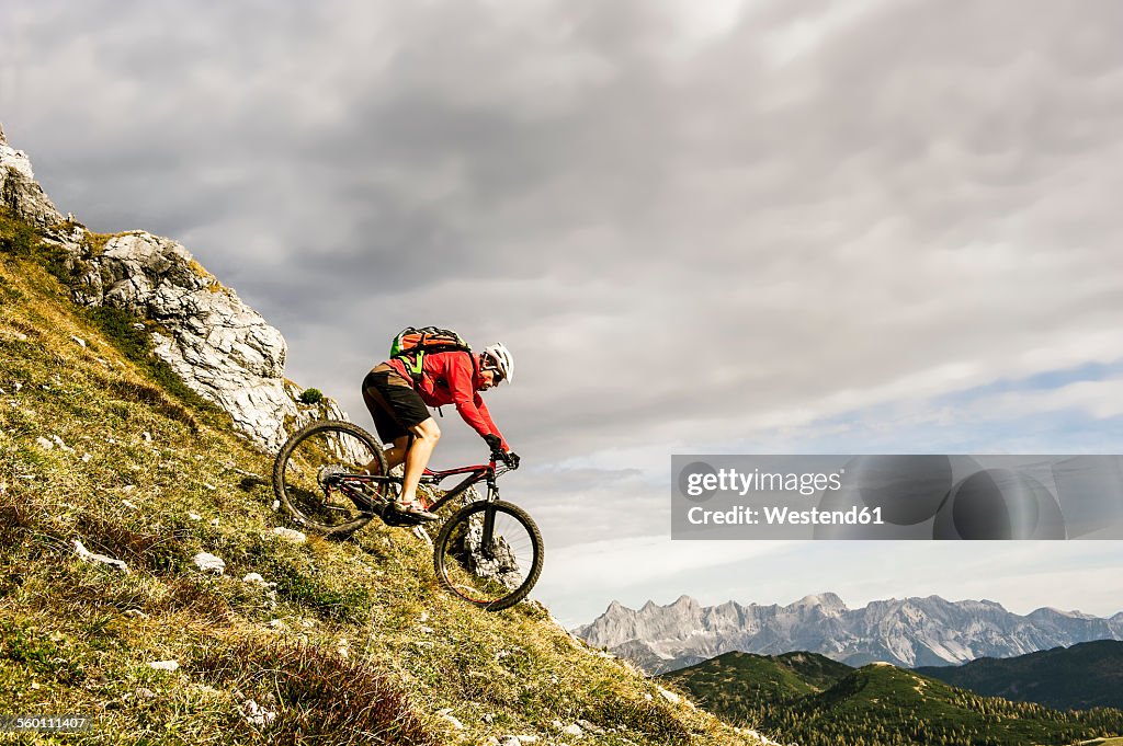 Austria, Altenmarkt-Zauchensee, young mountain biker driving at Low Tauern