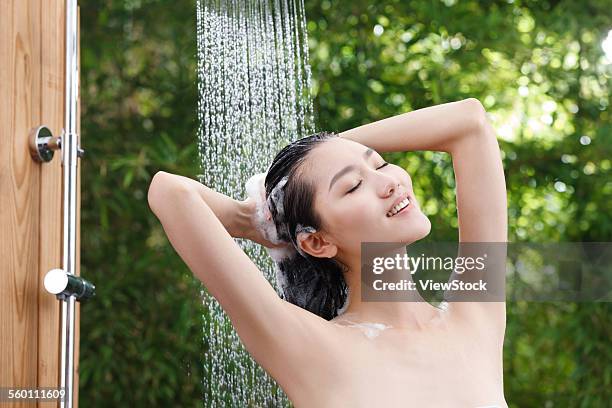 a young woman in the outdoor shower - femme shampoing photos et images de collection