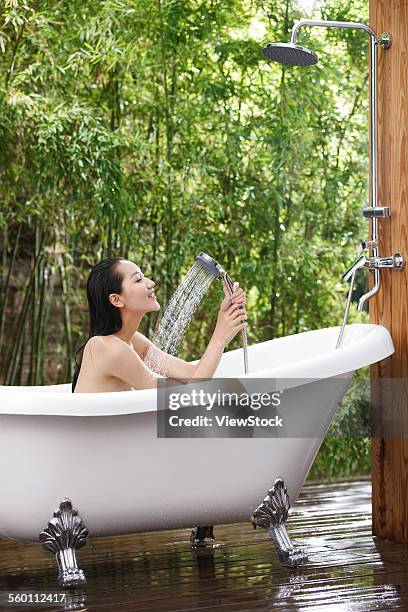 a young woman bathing in a bathtub - sunken bath stock pictures, royalty-free photos & images