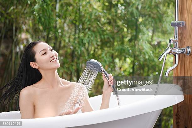 a young woman bathing in a bathtub - sunken bath stock pictures, royalty-free photos & images