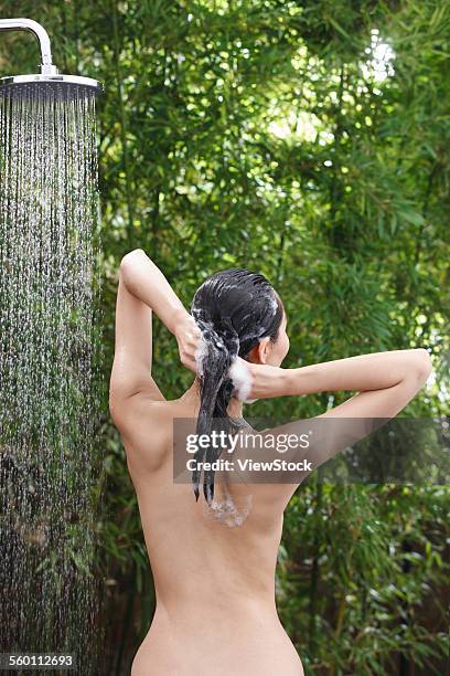 a young woman in the outdoor shower - woman taking a shower back view photos et images de collection