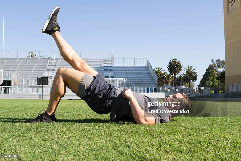 USA, California, San Luis Obispo, young man doing workout on an athletic field