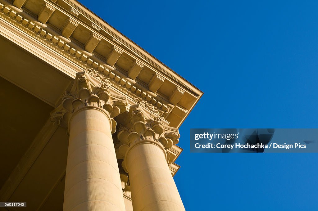 Stone architectural detail on the corner of a building against a blue sky
