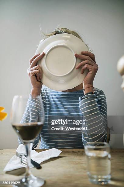 woman licking off a plate at home - lamber imagens e fotografias de stock