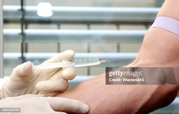 man receiving injection in arm - doping stock-fotos und bilder