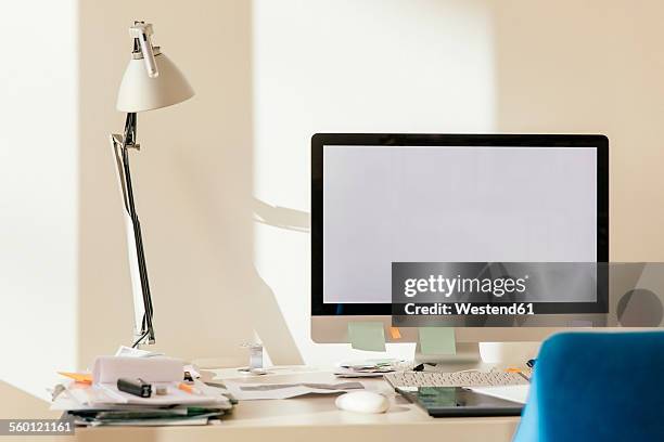 blank computer monitor on desk - schreibtischlampe stock-fotos und bilder