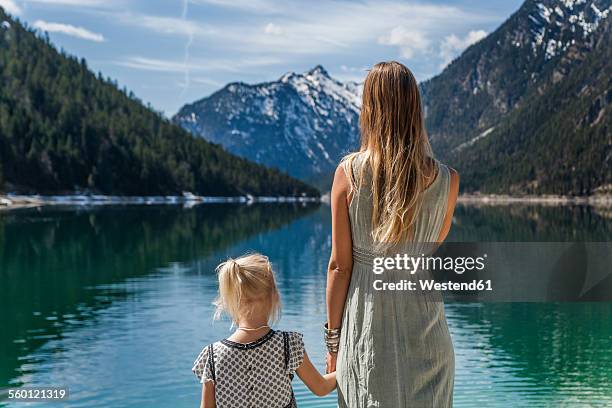 austria, tyrol, lake plansee, mother and daughter at lakeshore - women in see through dresses stock-fotos und bilder