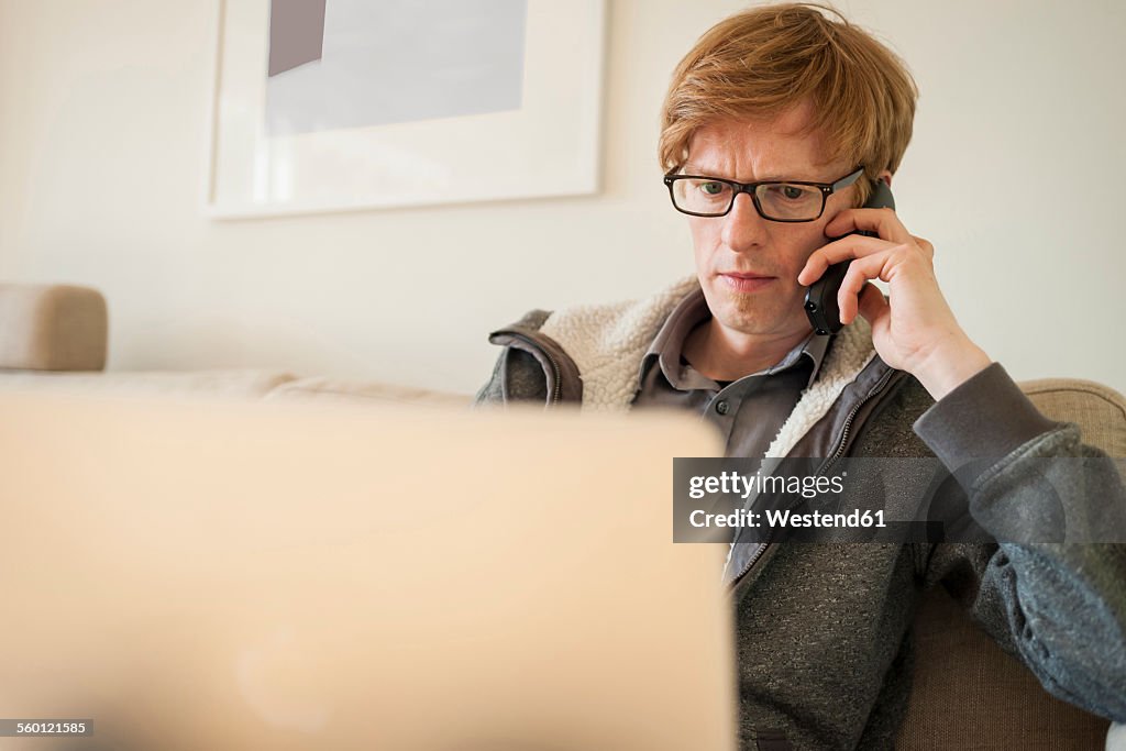 Man with laptop on the phone