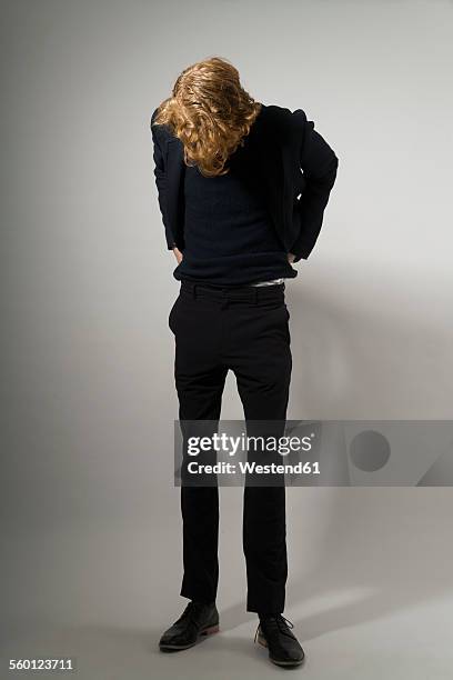 young man pulling his trousers up - slim stock pictures, royalty-free photos & images