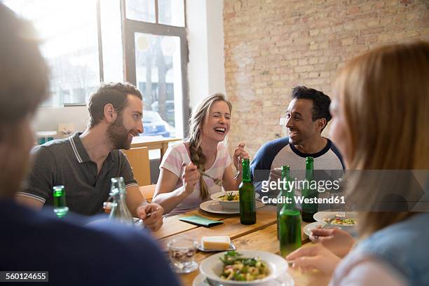 happy friends eating together - essen tisch stock-fotos und bilder