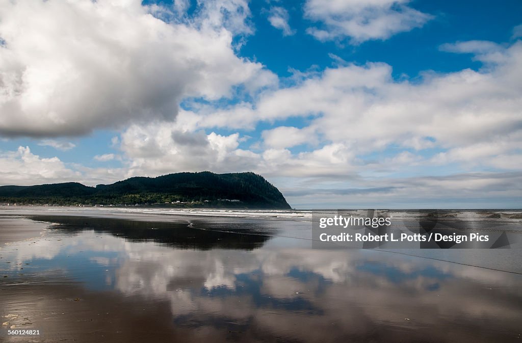 Clouds reflect on a beach near Tillamook Head