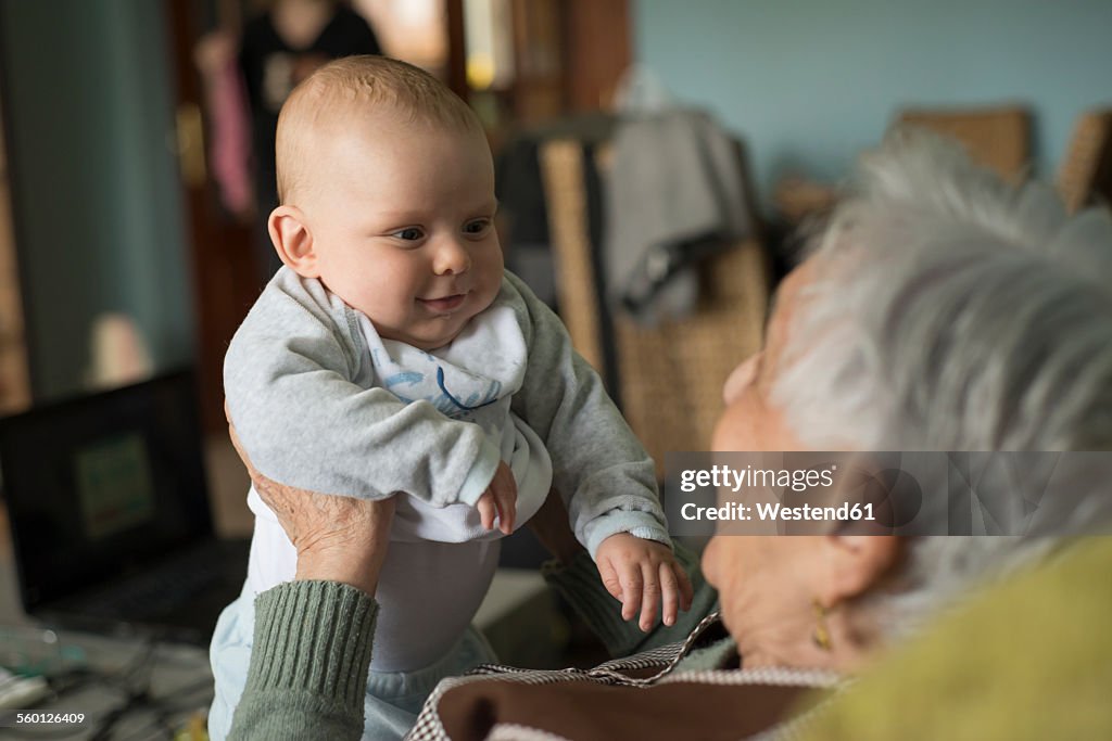 Baby boy smiling to an elderly woman at home