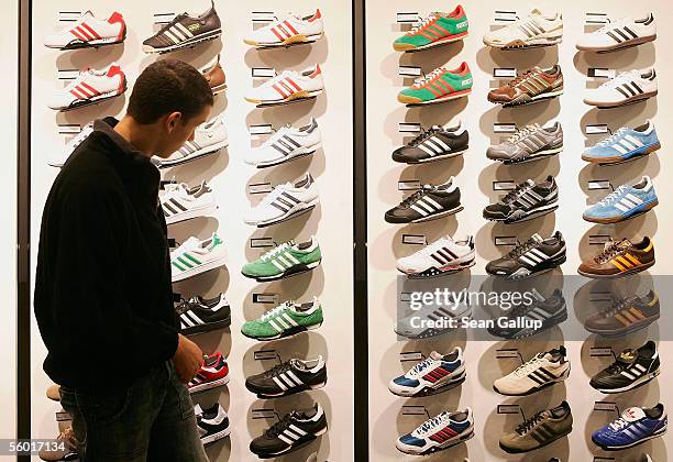 Man looks at Adidas shoes on display during the opening of the new Adidas Performance Store October 26, 2005 in Berlin, Germany. Adidas-Salomon AG is...