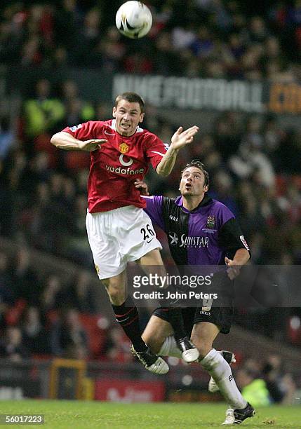 Phil Bardsley of Manchester United clashes with Giuliano Grazioli during the Carling Cup third round match between Manchester United and Barnet on...