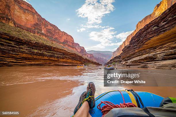 rafter floats down river with feet up. - colorado river stock pictures, royalty-free photos & images