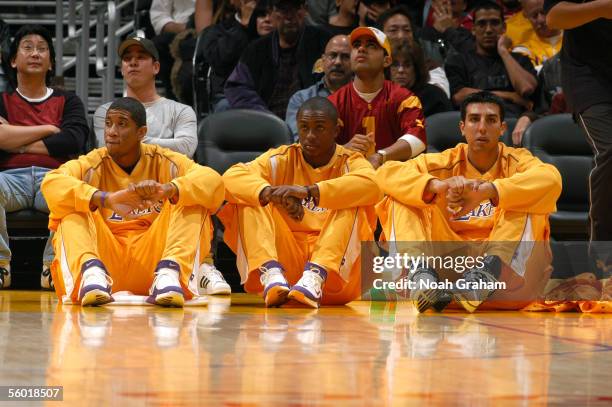 Devin Green, Von Wafer and Sasha Vujacic of the Los Angeles Lakers sit on the baseline next to the bench against the Charlotte Bobcats during a...