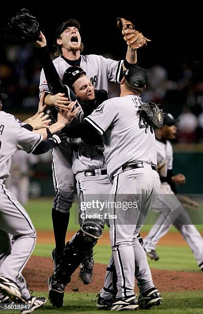 Joe Crede of the Chicago White Sox jumps onto teammates A.J. Pierzynski and Bobby Jenks in celebration after winning Game Four of the 2005 Major...