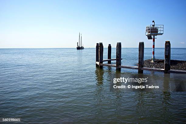 sailing boat arriving in small harbour - vlieland stock pictures, royalty-free photos & images