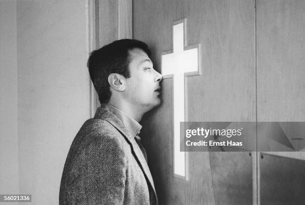 American film actor Tony Curtis peers through a church door before his wedding to his second wife Christine Kaufmann, February 1963.