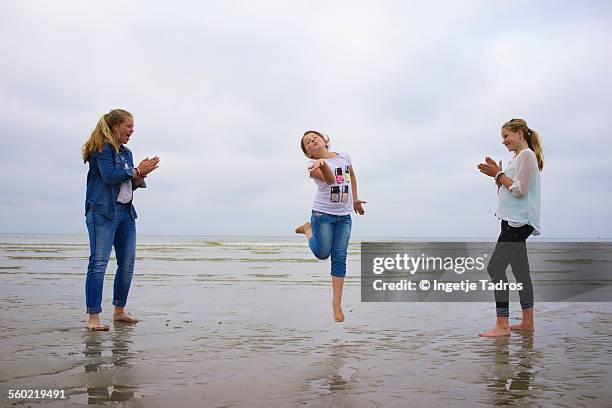 girls playing a fun game at the beach - vlieland stock pictures, royalty-free photos & images