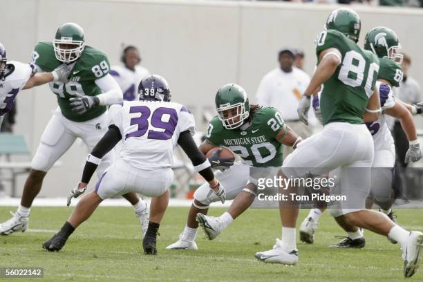 Running back Jason Teague of the Michigan State Spartans carries the ball against defensive back Brendan Smith of the Northwestern Wildcats at...