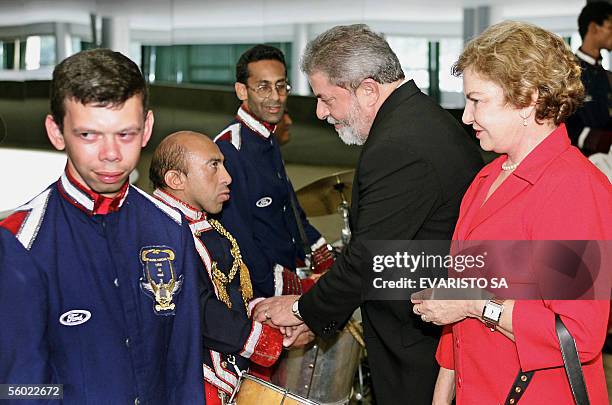 El Presidente de Brasil Luiz Inacio Lula da Silva y su esposa Marisa Leticia saludan a los miembros de un conjunto musical integrado por personas con...