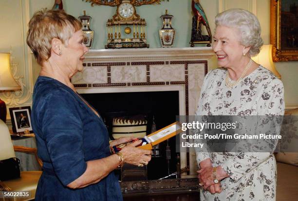 Queen Elizabeth II invests Dame Judi Dench with the Insignia of a Companion of Honour at Buckingham Palace