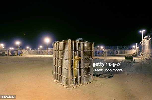 Juvenile detainee stands in a solitary confinement cage in the Abu Ghraib Prison October 27, 2005 which is located on the outskirts of Baghdad, Iraq....