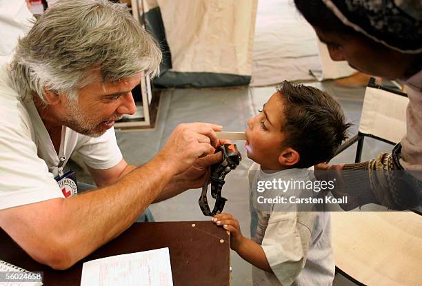 German doctor Richard Munz examines a young boy at the Basic Health Care of the German Red Cross on October 26, 2005 in Muzaffarabad, Pakistan...