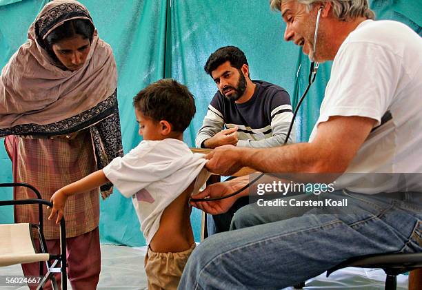 German doctor Richard Munz examines a young boy at the Basic Health Care of the German Red Cross on October 26, 2005 in Muzaffarabad, Pakistan...