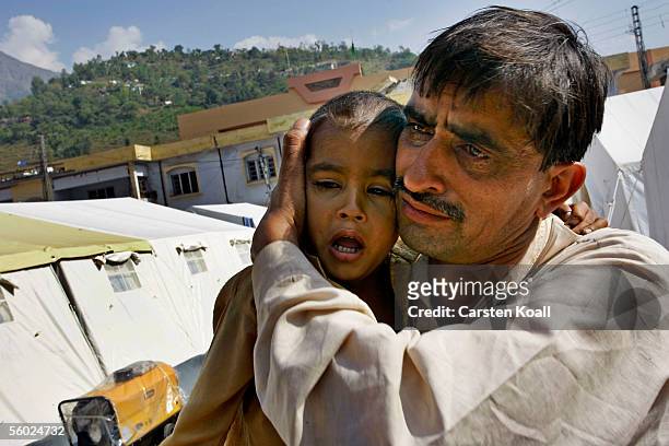 Emran Mustafa who lost his father in the earthquake, waits with his uncle at the Basic Health Care of the German Red Cross October 26, 2005 in...