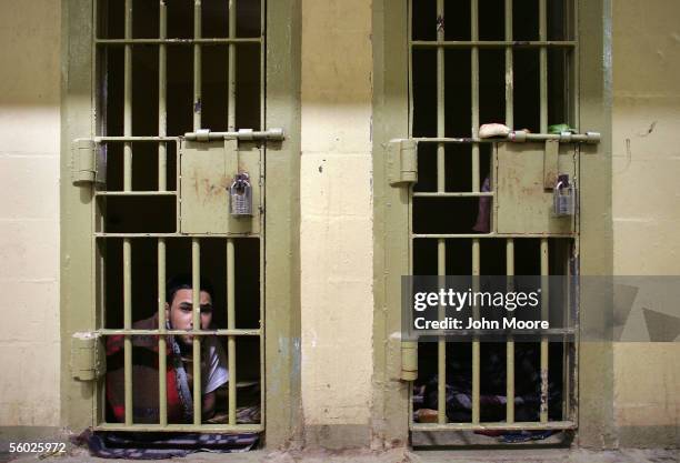 An Iraqi prisoner peers from his solitary confinement cell in the criminal section of the prison October 28, 2005 on the outskirts of Baghdad, Iraq....