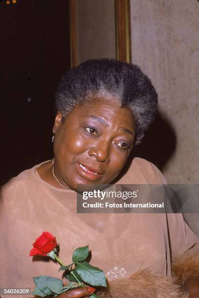 Portrait of American actress Esther Rolle , star of the this television show 'Good Times,' holding a rose, 1980s.