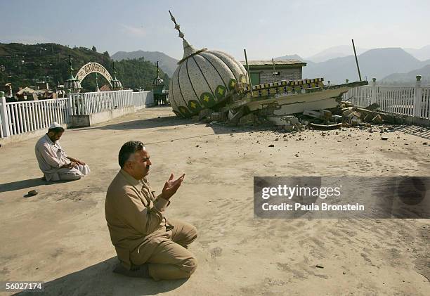 Pakistani men pray during Friday prayer on October 28, 2005 at the Jama Haman Wali mosque which was destroyed by the earthquake in Muzaffarabad,...