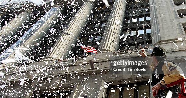 Chicago White Sox manager Ozzie Guillen waves to fans from a double-decker bus during a ticker-tape parade for the White Sox baseball team October...