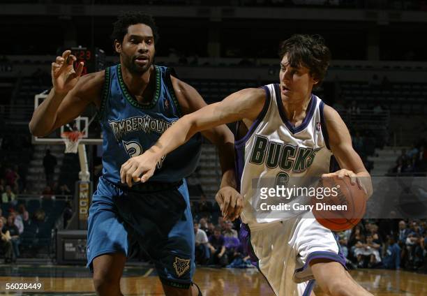 Andrew Bogut of the Milwaukee Bucks drives against Michael Olowokandi of the Minnesota Timberwolves during a NBA preseason game October 22, 2005 at...