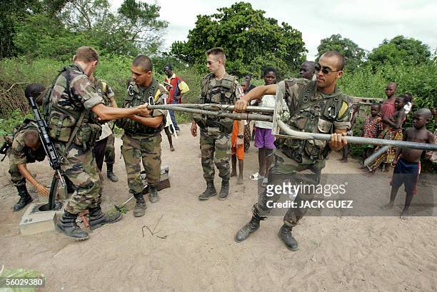 Des soldats Francais de la Force Licorne en Cote d'Ivoire, du 16e bataillon de chasseurs bases a Saarbourg en Allemagne, aident, le 27 octobre 2005,...