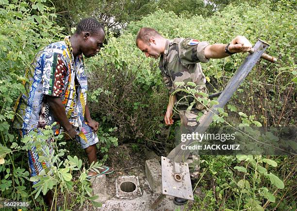 Un soldat Francais de la Force Licorne en Cote d'Ivoire, du 16e bataillon de chasseurs base a Saarbourg en Allemagne, aide, le 27 octobre 2005, des...